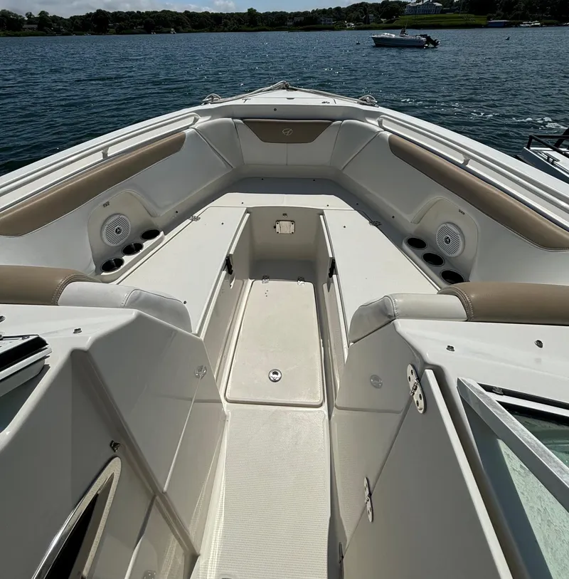 Slide: The Image of 2015 Sailfish 275 DC boat interior with spacious seating and storage, on a calm lake. - 14