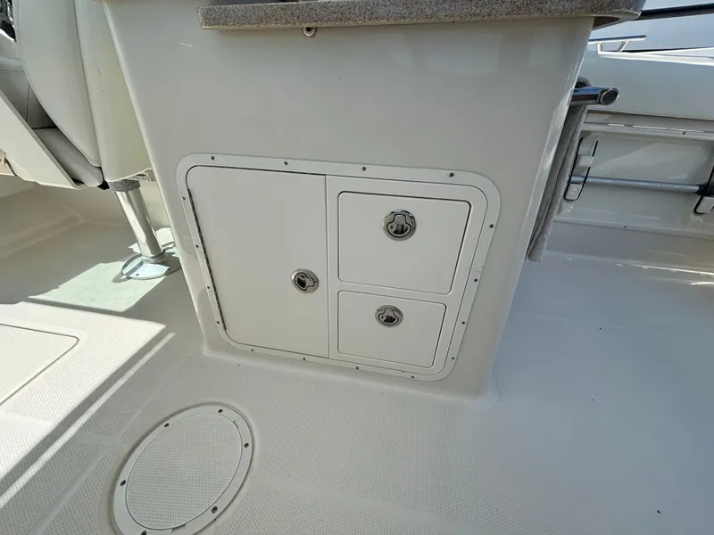 Slide: The Image of 2015 Sailfish 275 DC boat interior storage compartments and seating area. - 17
