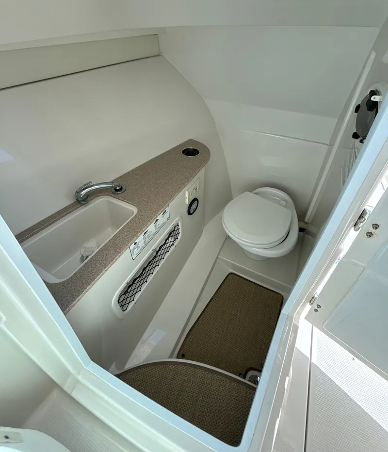 Slide: The Image of 2015 Sailfish 275 DC boat bathroom with sink and toilet. - 18