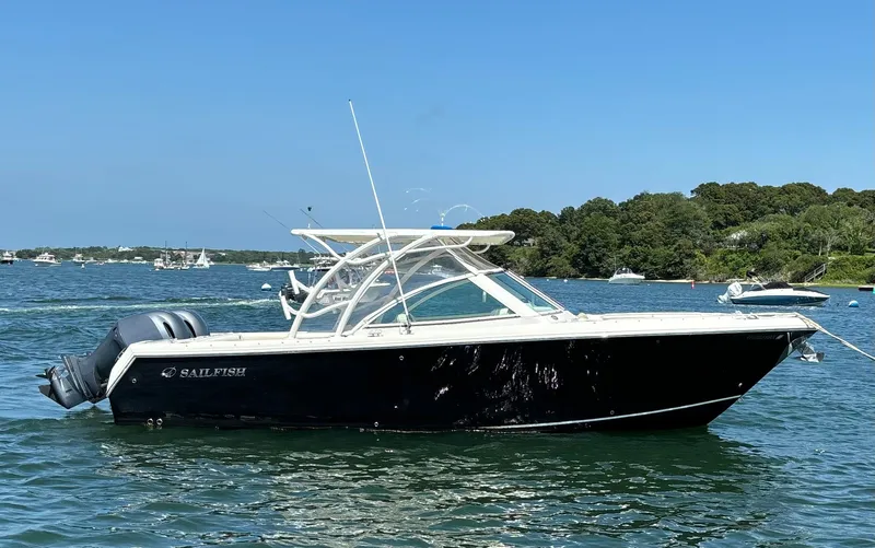 Slide: The Image of 2015 Sailfish 275 DC boat on a sunny lake with trees in the background. - 4