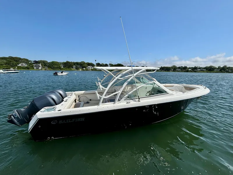 Slide: The Image of 2015 Sailfish 275 DC boat on calm water under clear blue sky. - 5