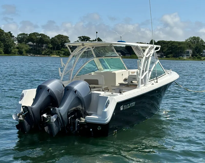 Slide: The Image of 2015 Sailfish 275 DC boat with dual outboard motors on a sunny lake. - 6