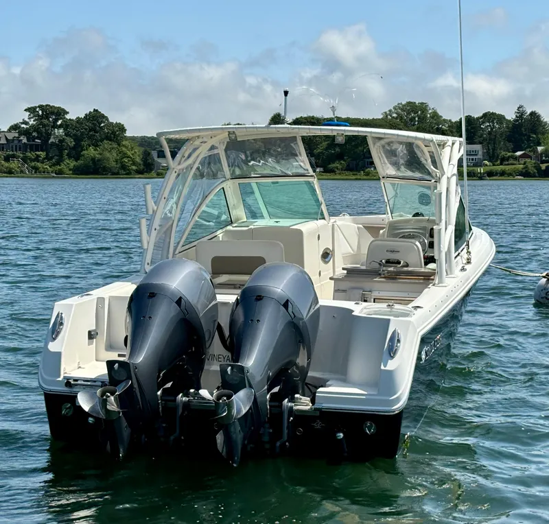 Slide: The Image of 2015 Sailfish 275 DC boat with dual outboard motors on a calm lake. - 7