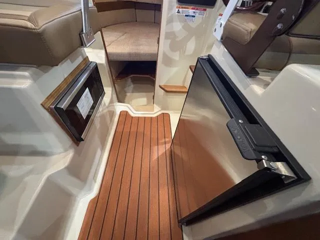 Slide: The Image of 2025 Ranger Tugs R-23 interior with wood flooring and compact kitchenette. - 12