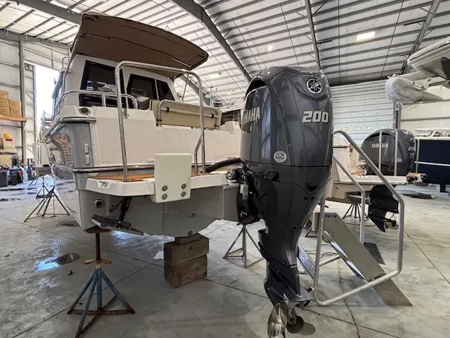 Slide: The Image of 2025 Ranger Tugs R-23 boat with Yamaha 200 outboard motor in a spacious indoor facility. - 3