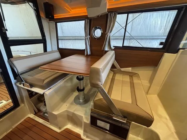 Slide: The Image of 2025 Ranger Tugs R-23 interior with dining area, wood accents, and modern seating. - 8