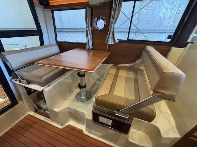 Slide: The Image of Interior of 2025 Ranger Tugs R-23 boat with seating and wooden table. - 9