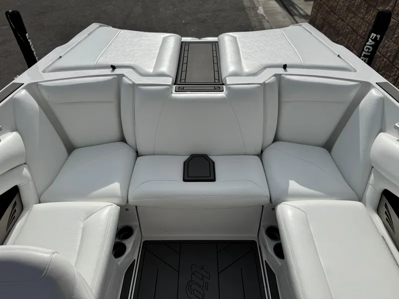 Slide: The Image of 2019 Tigé R21 boat interior with white leather seating and cup holders. - 21