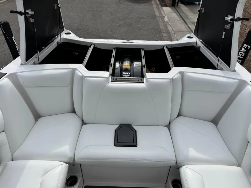 Slide: The Image of 2019 Tigé R21 boat interior with white seating and open storage compartments. - 22