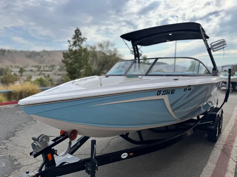 Slide: The Image of 2019 Tigé R21 boat on trailer, parked outdoors under cloudy sky. - 3