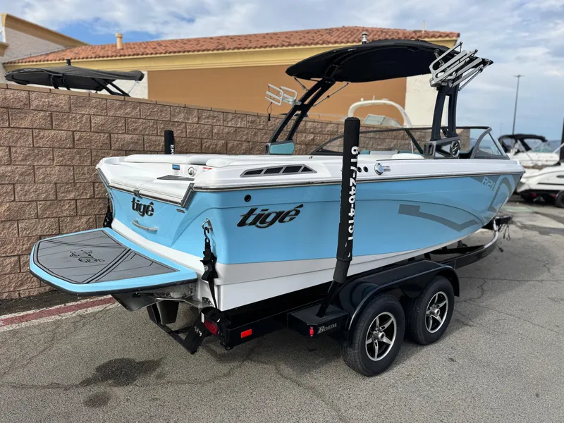 Slide: The Image of 2019 Tigé R21 boat on trailer, light blue and white, parked outdoors. - 5