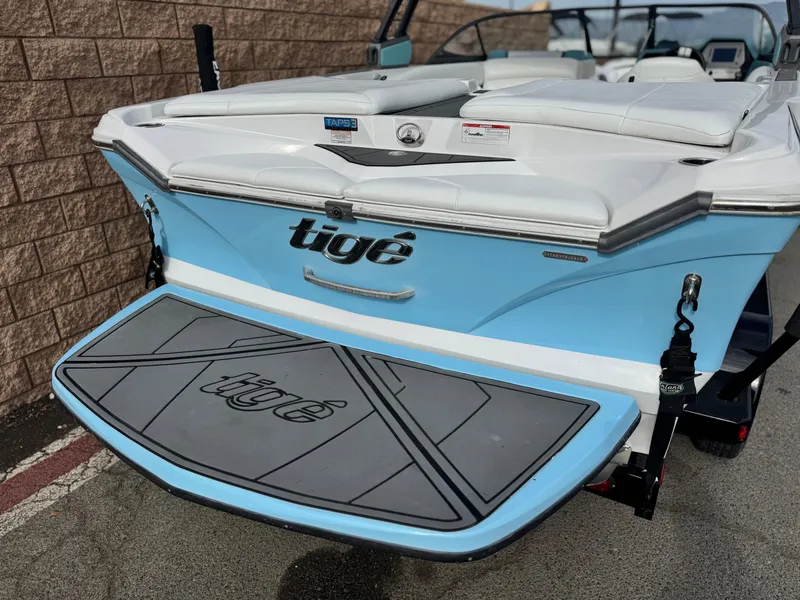 Slide: The Image of 2019 Tigé R21 boat with blue and white design, rear view showing swim platform. - 6
