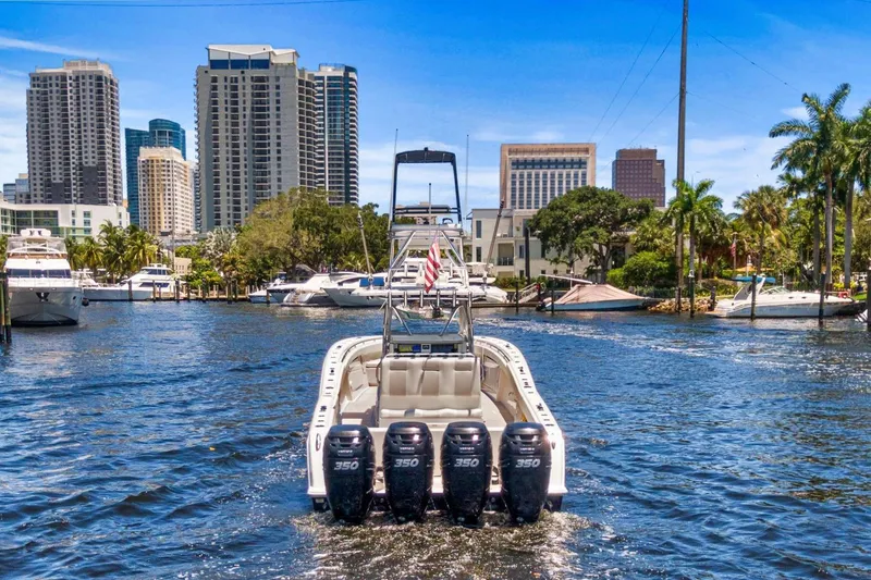 Slide: The Image of 2013 Invincible 42 Open Fisherman boat cruising in urban waterfront setting. - 11