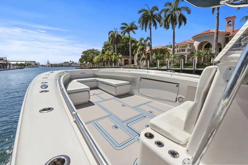 Slide: The Image of 2013 Invincible 42 Open Fisherman boat with spacious deck, docked near luxury waterfront homes. - 28