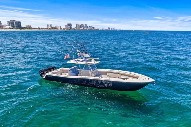 Slide: The Image of 2013 Invincible 42 Open Fisherman boat on blue ocean near city skyline. - 4