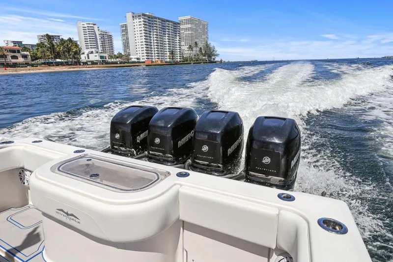 Slide: The Image of 2013 Invincible 42 Open Fisherman boat with four powerful engines cruising near city skyline. - 40