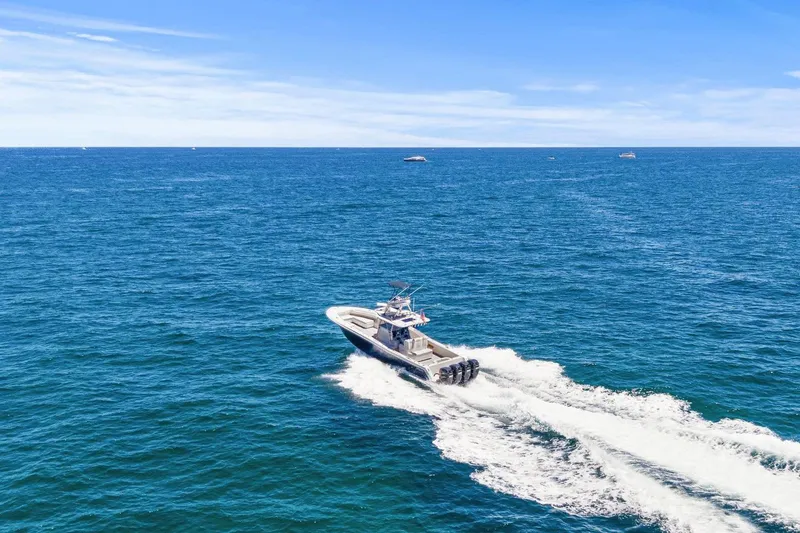 Slide: The Image of 2013 Invincible 42 Open Fisherman boat cruising on open ocean under clear blue sky. - 9
