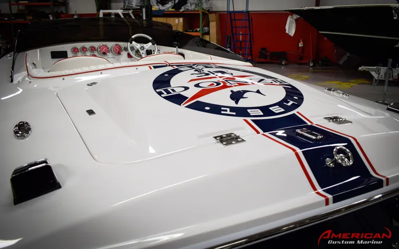 Slide: The Image of 2022 Donzi 22 Classic boat with logo, white and red interior, in a marine workshop. - 12