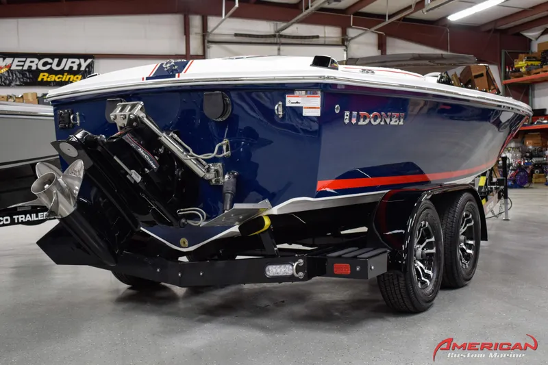 Slide: The Image of 2022 Donzi 22 Classic boat on trailer in showroom, featuring sleek blue design. - 6