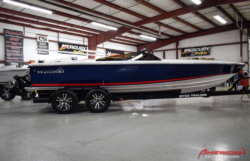 Slide: The Image of 2022 Donzi 22 Classic boat on trailer in showroom, blue and white design. - 7