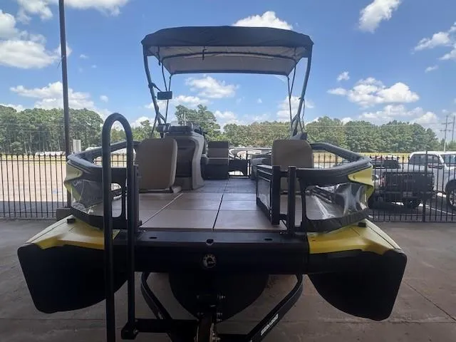 Slide: The Image of 2023 Sea-Doo Sport Boats 18 Switch Sport, docked, with canopy and seating, under a partly cloudy sky. - 2