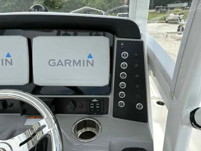 Slide: The Image of 2024 Robalo 246 Cayman boat dashboard with dual Garmin displays and control panel. - 12