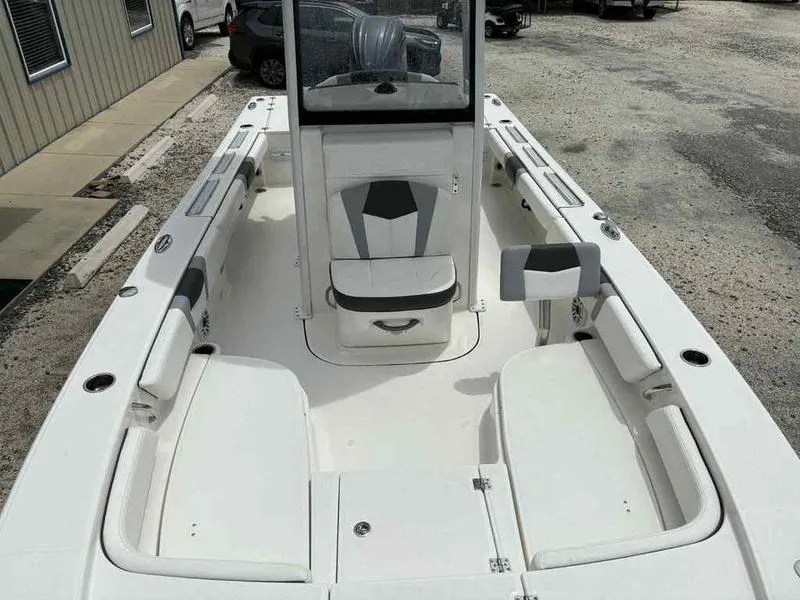 Slide: The Image of 2024 Robalo 246 Cayman boat interior with seating and console, parked on gravel. - 18