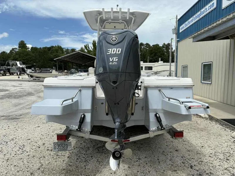 Slide: The Image of 2024 Robalo 246 Cayman boat with Yamaha 300 V6 engine, parked outdoors. - 2