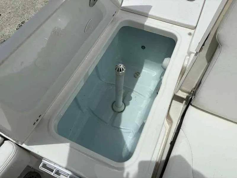 Slide: The Image of 2024 Robalo 246 Cayman boat livewell with open lid, showcasing interior design. - 20