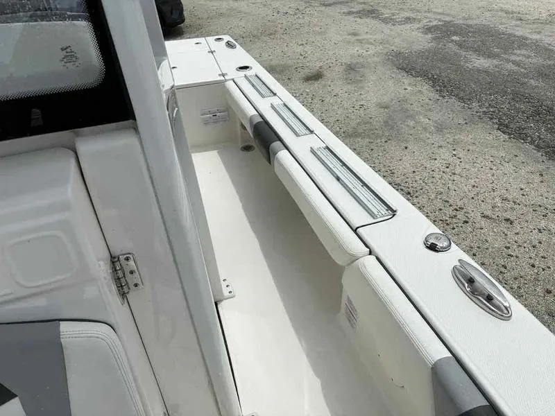 Slide: The Image of 2024 Robalo 246 Cayman boat interior with white seating and storage compartments. - 23