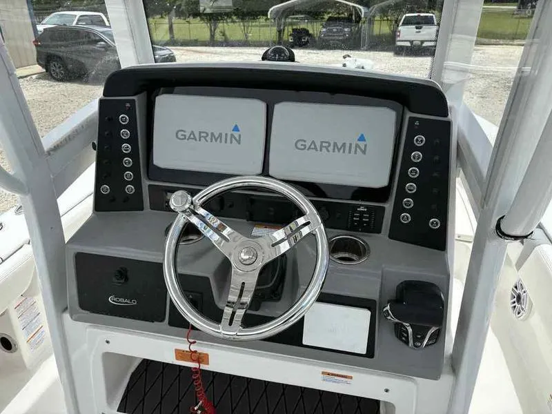 Slide: The Image of 2024 Robalo 246 Cayman boat dashboard with dual Garmin displays and steering wheel. - 29