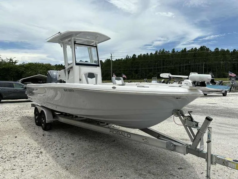 Slide: The Image of 2024 Robalo 246 Cayman boat on trailer, parked outdoors under a cloudy sky. - 5