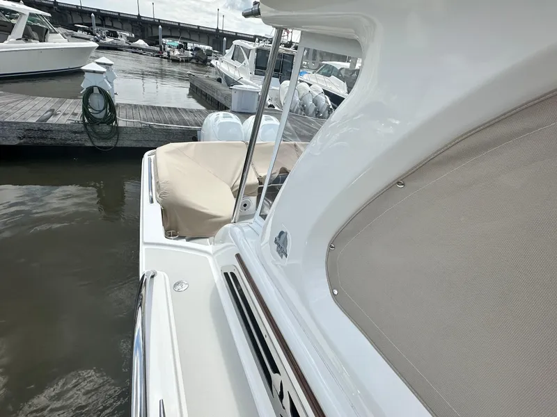 Slide: The Image of 2022 Back Cove 34O docked at marina, showcasing sleek design and covered seating area. - 25