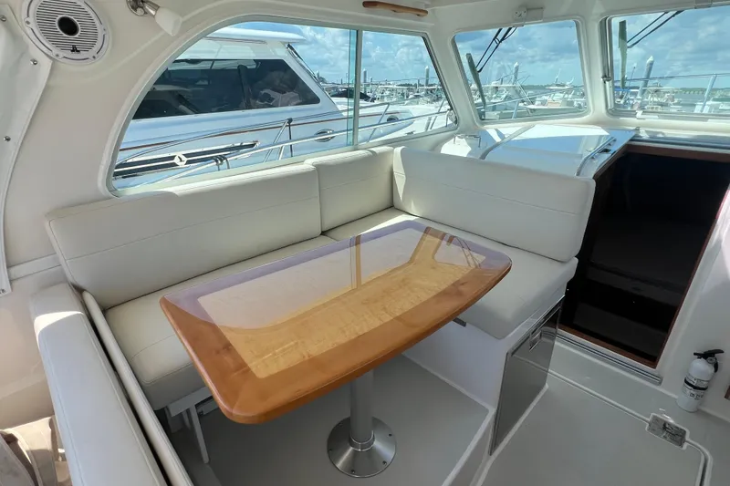 Slide: The Image of Interior of 2022 Back Cove 34O yacht with white seating and wooden table. - 33