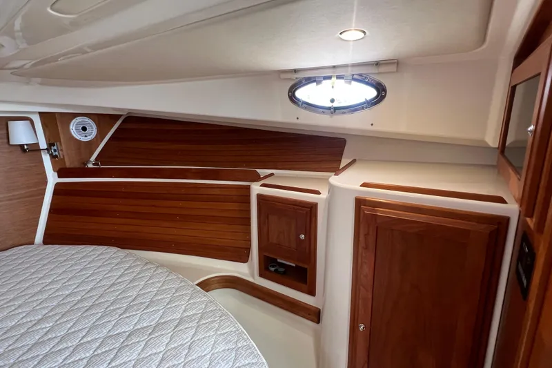 Slide: The Image of 2022 Back Cove 34O cabin interior with wood paneling and porthole window. - 36