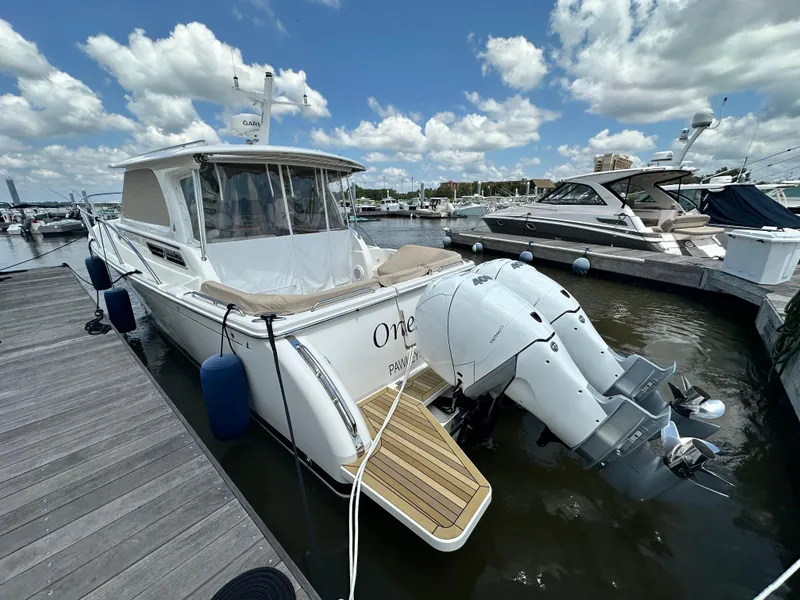 Slide: The Image of 2022 Back Cove 34O boat docked at marina under a partly cloudy sky. - 40
