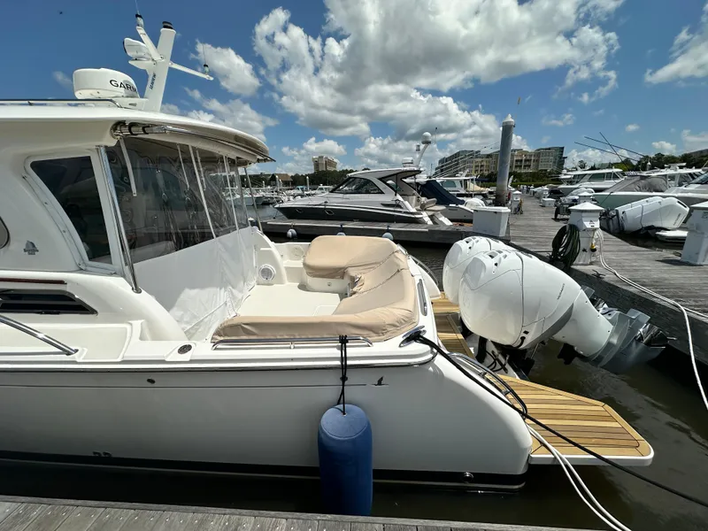 Slide: The Image of 2022 Back Cove 34O yacht docked at marina under a partly cloudy sky. - 42