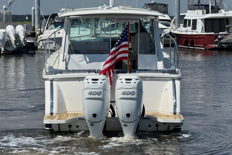 Slide: The Image of 2022 Back Cove 34O boat with twin 400 engines, docked with American flag. - 5