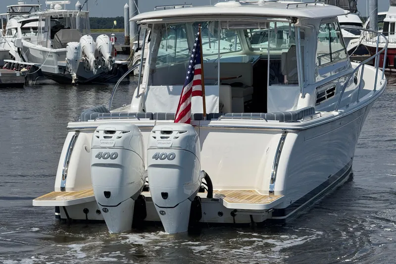 Slide: The Image of 2022 Back Cove 34O boat with twin 400 engines, docked in a marina. - 6