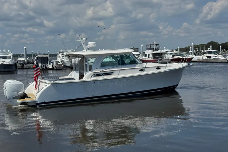 Slide: The Image of 2022 Back Cove 34O boat docked in a marina under a cloudy sky. - 7