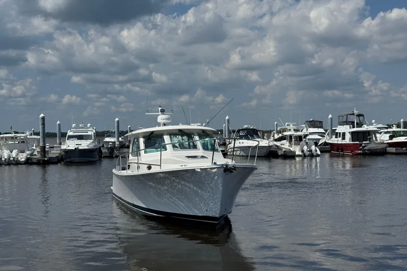 Slide: The Image of 2022 Back Cove 34O boat docked in a marina under a cloudy sky. - 8