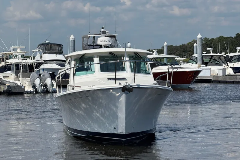Slide: The Image of 2022 Back Cove 34O boat docked at marina, surrounded by other vessels. - 9