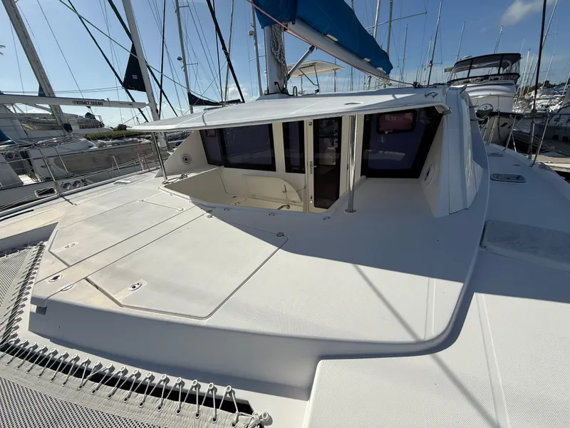 Slide: The Image of 2013 Leopard 44 catamaran docked, featuring spacious deck and modern design. - 22