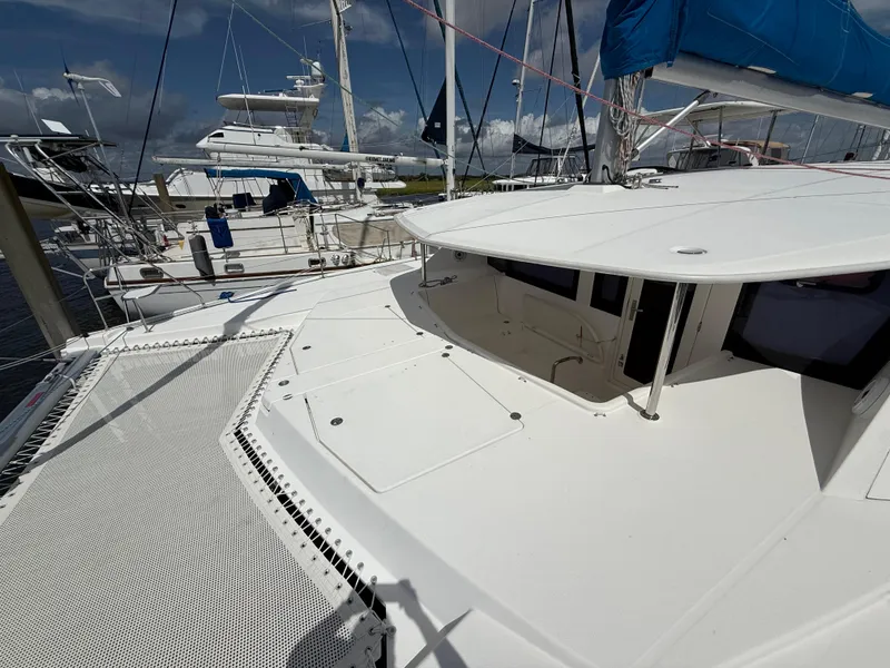 Slide: The Image of 2013 Leopard 44 catamaran docked, featuring spacious deck and modern design. - 23