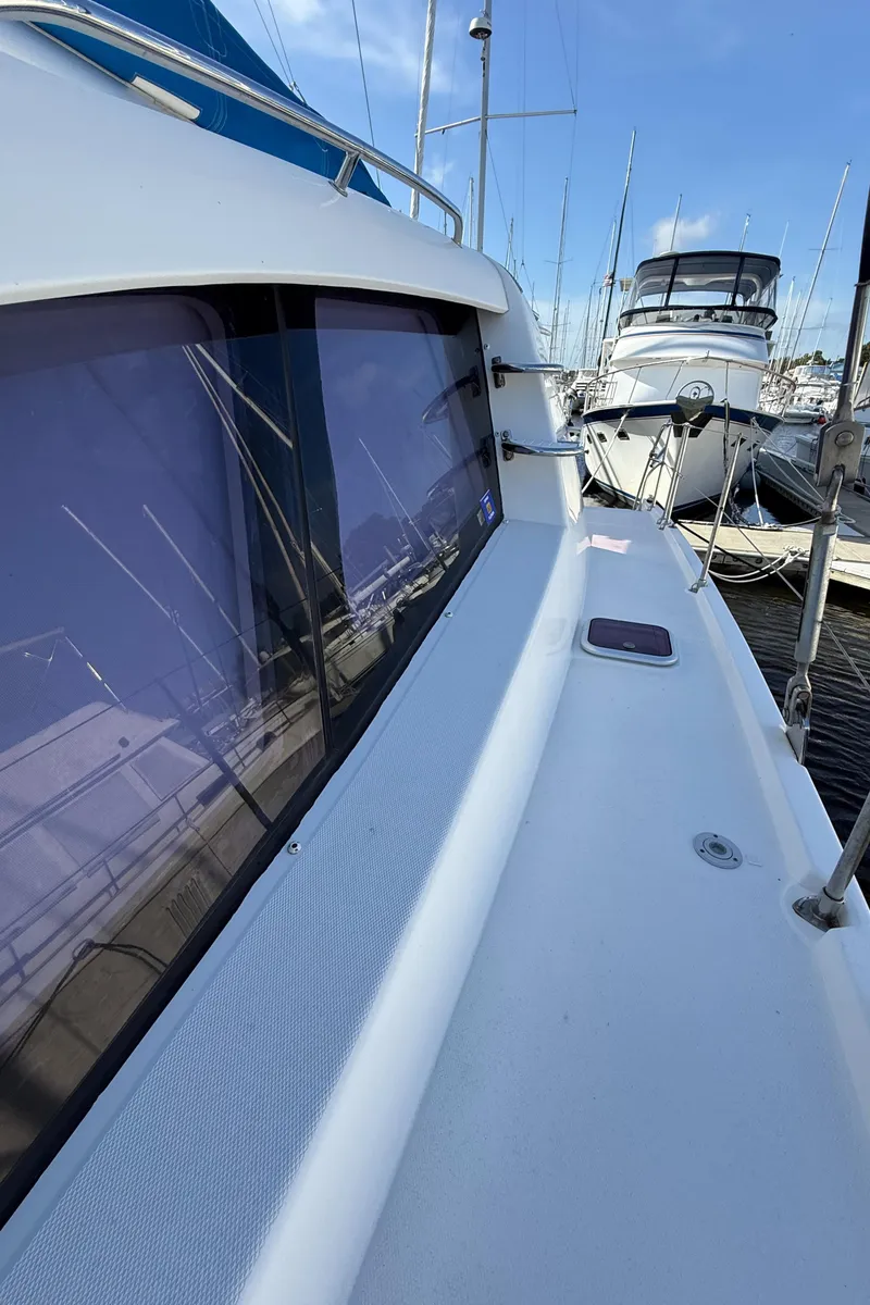 Slide: The Image of 2013 Leopard 44 yacht docked at marina, showcasing sleek design and spacious deck. - 29