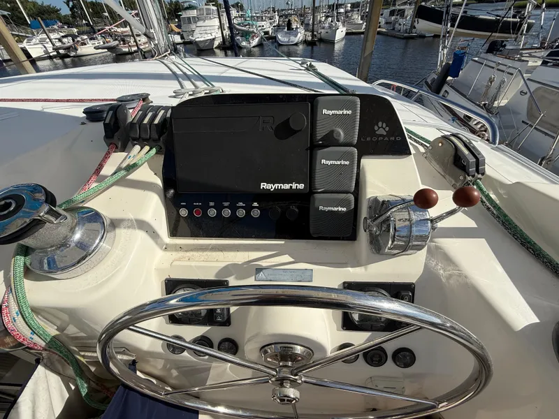 Slide: The Image of Steering wheel and controls of a 2013 Leopard 44 yacht at a marina. - 44