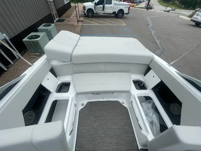 Slide: The Image of 2025 Four Winns H4 Freedom boat interior with white seating and storage compartments. - 5