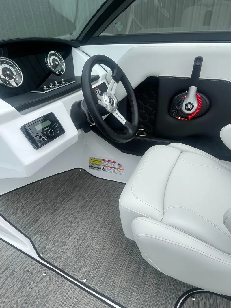 Slide: The Image of Interior of 2025 Four Winns H4 Freedom boat with steering wheel and dashboard controls. - 6