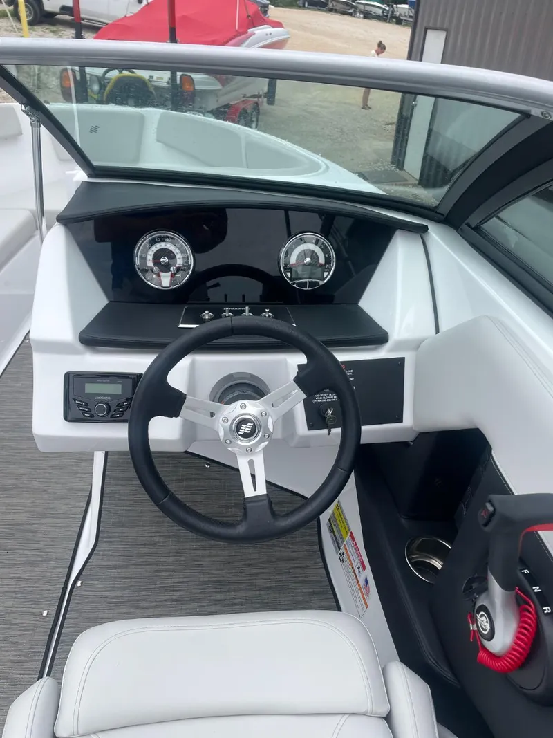 Slide: The Image of 2025 Four Winns H4 Freedom boat dashboard with steering wheel and gauges. - 7