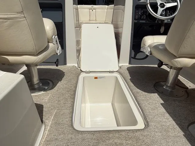 Slide: The Image of 2001 Chris-Craft Launch 25 interior with open storage compartment and beige seating. - 20